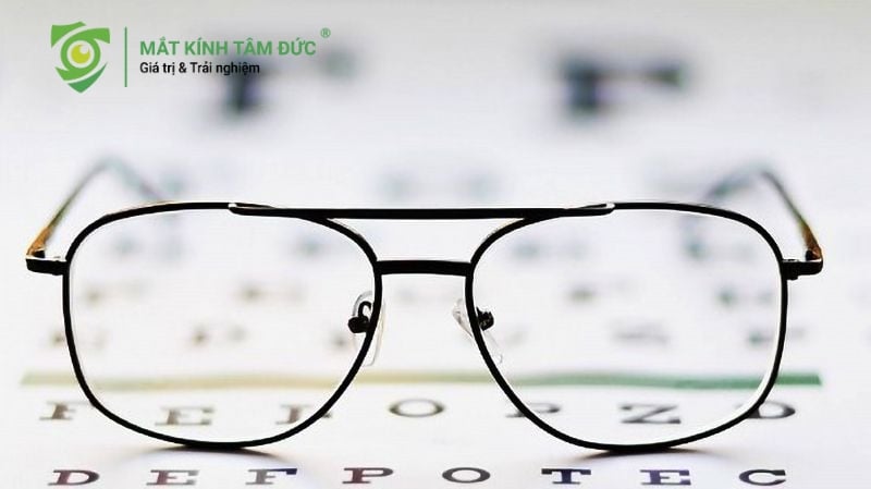 Kính cận đặt trên bảng đo thị lực, minh họa nguy cơ bị cận không đeo kính dẫn đến tăng độ nhanh chóng.