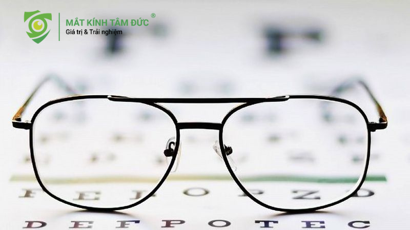 Kính cận đặt trên bảng đo thị lực, minh họa nguy cơ bị cận không đeo kính dẫn đến tăng độ nhanh chóng.