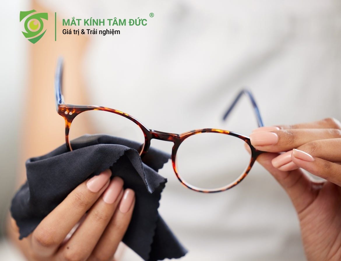 Một chiếc tròng kính dính đầy dấu vân tay, bụi bẩn hoặc vết dầu mỡ sẽ làm giảm độ trong suốt và gây tán xạ ánh sáng. Khi đó, mắt phải điều tiết liên tục để bù đắp tiêu điểm, dẫn đến việc đeo kính mới bị nhức đầu và mỏi mắt nhanh chóng. Hãy luôn mang theo khăn lau chuyên dụng và nước rửa kính để đảm bảo tầm nhìn luôn trong veo.
