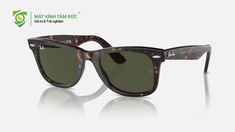 Key: mắt kính RayBanMeta: Phân biệt mắt kính RayBan thật giả chi tiết nhất từ hộp, tem, tròng kính đến check code, giúp bạn tránh hàng giả và chọn kính chính hãng an toàn.
12 cách phân biệt mắt kính RayBan thật giả chính xác nhất hiện nay
Sapo: Mắt kính RayBan thật giả ngày càng khó phân biệt, khiến nhiều người loay hoay khi chọn mua. Bài viết này sẽ hướng dẫn bạn 12 cách kiểm tra từ hộp, bao da, tròng kính đến mã code, giúp bạn tự tin lựa chọn sản phẩm chính hãng, vừa an toàn cho mắt vừa thời thượng. Cùng Mắt Kính Tâm Đức khám phá ngay để biết cách chọn kính phù hợp nhé.
Tại sao cần phân biệt mắt kính RayBan chính hãng?
Mắt kính RayBan là thương hiệu mắt kính nổi tiếng toàn cầu, được ưa chuộng nhờ thiết kế thời thượng và khả năng bảo vệ mắt vượt trội. Chính vì độ “hot” này mà thị trường hiện nay xuất hiện rất nhiều sản phẩm RayBan giả, nhái tinh vi, gây khó khăn cho người tiêu dùng trong việc nhận biết. Việc phân biệt kính RayBan chính hãng không chỉ giúp bạn tránh mất tiền oan mà còn bảo vệ trực tiếp thị lực và sức khỏe đôi mắt về lâu dài.
Thực trạng hàng mắt kính RayBan giả tại Việt Nam
Tại Việt Nam, mắt kính RayBan giả được bày bán tràn lan trên các sàn thương mại điện tử, mạng xã hội và nhiều cửa hàng nhỏ lẻ với mức giá rẻ bất thường. Hàng giả ngày càng được làm tinh vi, từ logo, bao bì đến phụ kiện đi kèm, khiến người mua dễ nhầm lẫn nếu không có kinh nghiệm. Không ít người vì ham rẻ hoặc thiếu thông tin đã vô tình mua phải mắt kính RayBan kém chất lượng mà không hề hay biết.
Những hậu quả khôn lường khi sử dụng kính RayBan giả
Việc sử dụng mắt kính RayBan giả là lựa chọn mà nhiều người vô tình mắc phải vì mức giá rẻ và hình thức bên ngoài khá giống hàng thật. Tuy nhiên, đằng sau đó là những hệ lụy không nhỏ mà người dùng nên cân nhắc:
Không bảo vệ mắt khỏi tia UV: Kính giả thường không có khả năng chống tia cực tím, khiến mắt dễ mỏi, khô và suy giảm thị lực khi tiếp xúc ánh nắng thường xuyên.
Gây nhức mắt, đau đầu: Tròng kính kém chất lượng, dễ méo hình hoặc sai tiêu cự làm mắt phải điều tiết liên tục, gây cảm giác khó chịu.
Ảnh hưởng đến làn da: Gọng kính làm từ vật liệu rẻ tiền có thể gây kích ứng, ngứa hoặc mẩn đỏ ở vùng mũi và tai.
Độ bền thấp, nhanh hỏng: Kính dễ trầy xước, gãy vỡ, không có bảo hành rõ ràng, dẫn đến tốn kém chi phí thay mới.
Giảm trải nghiệm và sự tự tin: Kính giả không mang lại cảm giác thoải mái và giá trị thẩm mỹ như sản phẩm chính hãng.
<Chỉ kính RayBan thật mới chống tia UV hiệu quả>
Nhìn chung, để bảo vệ đôi mắt và đảm bảo sự an tâm khi sử dụng lâu dài, người dùng nên lựa chọn mắt kính RayBan chính hãng tại các cửa hàng uy tín thay vì đánh đổi sức khỏe bằng những sản phẩm kém chất lượng.
Xem thêm: Cách đeo tai nghe không bị đau khi đeo kính: 5 mẹo bạn cần biết
2. Top 11 cách phân biệt mắt kính Rayban thật giả chính xác nhất hiện nay 
Hộp mắt kính RayBan
Hộp kính là chi tiết đầu tiên người mua có thể quan sát để nhận biết kính RayBan chính hãng hay không. Những sản phẩm RayBan chính hãng luôn được đóng gói cẩn thận, thể hiện rõ sự chỉn chu của thương hiệu ngay từ bao bì.
Hàng thật: Hộp làm từ bìa cứng dày, cầm chắc tay, logo RayBan in sắc nét. Trên hộp có đầy đủ thông tin như tên thương hiệu, mã sản phẩm, mã màu, nơi sản xuất và mã vạch, tất cả đều được in sắc sảo, dễ đọc.
Hàng giả: Hộp mỏng, nhẹ, logo in mờ hoặc lem, thiếu thông tin hoặc in sai chi tiết.
<Hộp kính RayBan thật có logo sắc nét và thông tin đầy đủ>
Bao da đựng kính
Bao da đi kèm thể hiện rõ mức độ hoàn thiện của kính RayBan chính hãng, bởi RayBan luôn đầu tư kỹ lưỡng từ sản phẩm chính đến phụ kiện đi kèm.
Hàng thật: Bao da có độ cứng cáp vừa phải, giữ form tốt và không bị biến dạng khi bóp nhẹ. Đường may thẳng, đều tay, các mũi chỉ chắc chắn và không bị xơ. Logo RayBan được dập chìm sắc nét, cân đối, khó bong tróc dù sử dụng lâu dài. 
Hàng giả: ao da thường mềm, dễ gập hoặc mất form sau thời gian ngắn sử dụng. Chất liệu da thô, sần hoặc có mùi nhựa nồng. 
<Bao da kính RayBan chính hãng chắc chắn và giữ form tốt>
Khăn lau mắt kính Rayban
Bên cạnh kính và bao da, khăn lau cũng là phụ kiện đi kèm giúp người mua kiểm tra tính chính hãng của mắt kính RayBan một cách trực quan. Sau đây là cách phân biệt sản phẩm RayBan thật, giả như sau: 
Hàng thật: Khăn được làm từ vải microfiber cao cấp, bề mặt mềm mịn, sờ êm tay và không gây trầy xước tròng kính khi sử dụng. Khăn ít xù lông, giữ form tốt sau nhiều lần giặt. Logo RayBan được in sắc nét, màu đều, đúng phông chữ và khó phai trong quá trình sử dụng.
Hàng giả: Khăn thường mỏng, chất vải thô ráp, dễ xù lông hoặc để lại bụi vải trên tròng kính và logo in nhạt.
<Khăn lau kính RayBan thật có logo sắc nét và khó phai màu>
Tem sản phẩm và chữ khắc chìm
Để nhận biết mắt kính RayBan thật hay giả, việc quan sát tem sản phẩm và chữ khắc chìm là bước kiểm tra quan trọng. Những chi tiết này tuy nhỏ nhưng thể hiện độ chính xác và tiêu chuẩn nghiêm ngặt chỉ có ở sản phẩm chính hãng.
Hàng thật: Tem in rõ ràng, chữ khắc chìm sắc nét, đúng font đặc trưng của RayBan.
Hàng giả: Tem mờ, chữ khắc nông, không đều hoặc dễ trầy xóa.
<Tem in rõ ràng và chữ khắc chìm đúng font chỉ có ở kính RayBan chính hãng>
Đệm mũi của mắt kính Rayban
Đệm mũi là bộ phận nhỏ nhưng quan trọng, quyết định sự thoải mái và trải nghiệm khi đeo kính RayBan. Sau đây là những thông tin chi tiết về đệm mũi của mắt kính Rayban 
Hàng thật: Đệm mũi mềm, đàn hồi tốt, không gây đau sống mũi khi đeo lâu.
Hàng giả: Đệm cứng, nhanh ố màu, dễ gây khó chịu.
<Đệm mũi kính RayBan thật tạo cảm giác thoải mái khi đeo lâu>
Sách hướng dẫn, phiếu bảo hành
Khi mua kính RayBan, kiểm tra sách hướng dẫn và phiếu bảo hành là bước quan trọng để xác nhận sản phẩm chính hãng. RayBan luôn cung cấp đầy đủ giấy tờ đi kèm cho sản phẩm chính hãng.
Hàng thật: Có sách hướng dẫn và phiếu bảo hành in trên giấy dày, nội dung rõ ràng.
Hàng giả: Thiếu giấy tờ hoặc in sơ sài, thông tin không nhất quán.
 <Việc thiếu giấy tờ đi kèm là dấu hiệu cần cân nhắc trước khi mua.
Tròng kính
Khi kiểm tra mắt kính RayBan, tròng kính là yếu tố then chốt để đánh giá chất lượng và tính chính hãng của sản phẩm.
Hàng thật: Hình ảnh trong, không méo, chống tia UV tốt, đeo lâu không mỏi mắt.
Hàng giả: Dễ nhòe, chói, gây nhức mắt và đau đầu.
 <Tròng kính chất lượng kém không chỉ gây khó chịu mà còn ảnh hưởng đến thị lực.
Bản lề kính
Bản lề là chi tiết nhỏ nhưng quyết định sự chắc chắn và độ bền lâu dài của kính RayBan. Một bản lề chất lượng kém có thể khiến kính nhanh hư hỏng và gây bất tiện khi sử dụng.
Hàng thật: Gập mở mượt mà, chắc tay, không phát ra tiếng.
Hàng giả: Bản lề lỏng, kẹt, nhanh hỏng.
< Bản lề kém chất lượng sẽ làm giảm tuổi thọ của kính.
Gọng kính RayBan
Khi quan sát gọng kính RayBan, bạn sẽ nhận thấy ngay sự khác biệt về chất lượng và độ cân đối giữa hàng thật và hàng giả. 
Hàng thật: Cầm chắc tay, không lệch, chữ in rõ và đúng kiểu chữ RayBan. Ví dụ, mẫu gọng kính RayBan 0RX5315D được làm từ nhựa dẻo cao cấp, màu đen bóng, cầm chắc tay và rất cân đối, các chữ in trên gọng rõ ràng và đúng kiểu chữ RayBan.
Hàng giả: Nhẹ bất thường, dễ cong vênh, chữ in mờ hoặc sai font.
 <Một chiếc gọng đẹp và cân đối thường chỉ có ở kính chính hãng.
Cách check code kính RayBan
Mã code là thông tin quan trọng giúp người mua kiểm tra nguồn gốc kính. Để đảm bảo mua được kính RayBan chính hãng, việc kiểm tra mã code đi kèm là bước không thể bỏ qua.
Hàng thật: Có mã code rõ ràng, tra cứu được thông tin trên website chính thức.
Hàng giả: Mã sai, thiếu hoặc không thể kiểm tra.
Nguồn gốc xuất xứ và giấy tờ đi kèm
Xác định nguồn gốc xuất xứ và giấy tờ đi kèm là bước cuối cùng nhưng thiết yếu để đảm bảo mua được kính RayBan chính hãng.
Hàng thật: Mua tại đại lý ủy quyền, có hóa đơn và chứng từ đầy đủ.
Hàng giả: Bán trôi nổi, không chứng minh được xuất xứ, giá rẻ bất thường. 
Xem thêm: Top 5 mẫu gọng kính Ray-Ban “huyền thoại” không lỗi mốt năm 2026

Có nên mua mắt kính RayBan xách tay không?
Thực tế, việc mua kính RayBan xách tay không phải lúc nào cũng xấu, nhưng nó chỉ thực sự phù hợp trong những trường hợp cụ thể:
Có kiến thức và kinh nghiệm: Người mua cần biết phân biệt hàng thật và hàng giả, từ tem, logo, tròng kính đến phụ kiện đi kèm.
Nguồn mua tin cậy: Nên mua từ bạn bè, người thân ở nước ngoài hoặc các cửa hàng uy tín đã kiểm chứng.
Chấp nhận rủi ro về bảo hành và đổi trả: Người mua cần sẵn sàng nếu sản phẩm không được bảo hành chính hãng hoặc gặp khó khăn khi đổi trả.
<Mua kính RayBan xách tay chỉ phù hợp với người có kinh nghiệm>
Đối với đa số người tiêu dùng phổ thông, việc mua kính RayBan xách tay vẫn tiềm ẩn nhiều nguy cơ hơn lợi ích. Nếu không có kinh nghiệm kiểm tra kỹ sản phẩm, bạn rất dễ mua phải kính giả, tròng kính kém chất lượng, không bảo vệ mắt khỏi tia UV và gặp rủi ro về sức khỏe đôi mắt cũng như chi phí thay thế sau này.
Những rủi ro cần biết khi mua mắt kính RayBan xách tay
Mua mắt kính RayBan xách tay tưởng chừng là cách tiết kiệm nhưng lại tiềm ẩn nhiều rủi ro mà người dùng cần nắm rõ trước khi quyết định. Sau đây là những rủi ro mà Mắt Kinh Tâm Đức đã tìm hiểu giúp bạn, hy vọng sẽ cung cấp những thông tin hữu ích để bạn có thể lựa chọn được sản phẩm chính hãng và an toàn. 
Không đảm bảo nguồn gốc xuất xứ
Phần lớn kính RayBan xách tay không có hóa đơn, chứng từ nhập khẩu hoặc giấy xác nhận phân phối chính hãng. Điều này khiến người mua khó xác định kính có thực sự là hàng chính hãng hay chỉ là hàng trôi nổi đội lốt xách tay.
 Dễ mua phải kính RayBan giả, nhái tinh vi
Hiện nay, kính RayBan giả được làm rất giống hàng thật, từ hộp, bao da đến mã code. Người mua thiếu kinh nghiệm rất dễ nhầm lẫn, đặc biệt khi người bán quảng cáo là “xách tay từ Mỹ, Ý”. Kính giả thường có:
Tròng kính không chống tia UV đúng chuẩn
Hình ảnh nhìn qua bị méo, chói
Chất liệu gọng kém bền
Không được bảo hành chính hãng
Khi mua kính RayBan tại đại lý ủy quyền, người dùng sẽ được hưởng chính sách bảo hành chính hãng theo tiêu chuẩn của RayBan. Ngược lại, kính xách tay hầu như không có bảo hành rõ ràng, hoặc chỉ bảo hành miệng từ người bán, gây bất lợi nếu kính gặp lỗi.
Khó kiểm tra mã code và thông tin sản phẩm
Nhiều mẫu kính RayBan xách tay thường khó kiểm tra mã code và thông tin sản phẩm, do mã code có thể được in sai chuẩn hoặc không đúng định dạng của hãng. Bên cạnh đó, các thông tin trên gọng kính như model, kích thước, màu sắc đôi khi không trùng khớp khi tra cứu, khiến người mua khó xác minh tính chính hãng. 
Trong nhiều trường hợp, kính còn không xác định được chính xác nơi sản xuất, làm giảm độ tin cậy và tiềm ẩn nguy cơ mua phải hàng kém chất lượng.
Nguy cơ ảnh hưởng đến sức khỏe đôi mắt
Tròng kính kém chất lượng, không đạt chuẩn chống tia UV có thể gây nhức mỏi mắt, đau đầu và làm giảm thị lực khi sử dụng lâu dài. Đặc biệt, với những người thường xuyên đeo kính khi lái xe hoặc đi ngoài trời nắng, các rủi ro này càng trở nên đáng lo ngại và dễ ảnh hưởng trực tiếp đến sinh hoạt hằng ngày.
<Kính RayBan xách tay khó kiểm tra mã code và nguồn gốc xuất xứ>
Những rủi ro từ việc mua kính RayBan xách tay không chỉ ảnh hưởng đến trải nghiệm khi sử dụng mà còn tiềm ẩn nguy cơ về chất lượng và sức khỏe thị lực. Lựa chọn mua kính tại đại lý ủy quyền hoặc cửa hàng uy tín sẽ đảm bảo sản phẩm chính hãng, được bảo hành đầy đủ và giúp bạn an tâm tuyệt đối khi sử dụng.
Lưu ý quan trọng khi mua mắt kính RayBan chính hãng
Khi mua mắt kính RayBan, ngoài kiểu dáng, người dùng cần nắm các lưu ý để đảm bảo sản phẩm chính hãng, chất lượng và an toàn cho mắt. Dưới đây là thông tin về giá cả và địa chỉ uy tín bạn nên biết.
Giá kính RayBan chính hãng dao động bao nhiêu?
Giá kính RayBan chính hãng tại Việt Nam thường dao động từ khoảng 3.000.000 đến 6.000.000 đồng, tùy vào dòng kính, kiểu dáng, chất liệu gọng và công nghệ tròng kính đi kèm. Các mẫu kính RayBan Polarized, RayBan chống tia UV cao cấp hoặc phiên bản giới hạn thường có mức giá cao hơn so với các dòng phổ thông. Nếu bạn gặp những sản phẩm được rao bán với giá quá rẻ so với mặt bằng chung, khả năng cao đó là kính RayBan giả hoặc hàng không rõ nguồn gốc.
Mua kính RayBan chính hãng ở đâu uy tín?
Để đảm bảo mua đúng mắt kính RayBan chính hãng, bạn nên ưu tiên lựa chọn các cửa hàng mắt kính lớn, hệ thống phân phối chính thức hoặc đại lý được ủy quyền của RayBan tại Việt Nam. Những địa chỉ uy tín thường cung cấp đầy đủ hộp đựng, khăn lau, thẻ bảo hành và hóa đơn rõ ràng. Ngoài ra, bạn nên tránh mua kính RayBan qua các trang bán hàng cá nhân không có thông tin minh bạch, vì rất khó kiểm chứng nguồn gốc sản phẩm và quyền lợi bảo hành sau này.
<Để đảm bảo chính hãng cần kiểm tra hộp đựng khăn lau thẻ bảo hành và hóa đơn>

Xem thêm: 10+ mẫu kính đi biển cho nam, nữ trẻ trung thời thượng năm 2025
Nhìn chung, việc lựa chọn mắt kính RayBan chính hãng không chỉ giúp bạn sở hữu sản phẩm thời trang, chất lượng mà còn đảm bảo an toàn cho sức khỏe đôi mắt. Bằng cách kiểm tra kỹ các chi tiết như hộp đựng, bao da, tròng kính, tem sản phẩm, mã code và mua tại đại lý uy tín, bạn hoàn toàn có thể tránh được những rủi ro từ hàng giả, hàng xách tay kém chất lượng. Hãy ghé ngay Mắt kính Tâm Đức để được khám mắt, tư vấn chọn kính phù hợp và sở hữu mắt kính RayBan chính hãng, bảo vệ tối ưu thị lực của bạn.

An tâm tuyệt đối khi chăm sóc kính tại Mắt kính Tâm Đức
Thay vì lo lắng về rủi ro làm hỏng cặp kính yêu thích, hãy để Mắt kính Tâm Đức giúp bạn chăm sóc đôi mắt và phụ kiện của mình một cách chuyên nghiệp nhất. Khi đến với chúng tôi, bạn sẽ được:
Kỹ thuật viên tay nghề cao trực tiếp thao tác tháo lắp, vệ sinh tròng kính bằng thiết bị chuyên dụng, đảm bảo không một vết trầy xước.
Hỗ trợ xử lý các ca khó như gọng khoan không viền, gọng kim loại mảnh hoặc tròng kính chiết suất cao đắt tiền.
Kiểm tra và cân chỉnh độ ổn định của kính sau khi lắp, giúp kính luôn vừa vặn và mang lại tầm nhìn tốt nhất cho mắt.
Tư vấn bảo dưỡng lớp phủ để giữ cho tròng kính luôn trong veo như mới.
Đặt lịch hẹn trực tuyến ngay để được kỹ thuật viên Mắt kính Tâm Đức hỗ trợ tận tình: Tại đây

Key: mắt kính RayBan
Meta: Phân biệt mắt kính RayBan thật giả chi tiết nhất từ hộp, tem, tròng kính đến check code, giúp bạn tránh hàng giả và chọn kính chính hãng an toàn.
12 cách phân biệt mắt kính RayBan thật giả chính xác nhất hiện nay
Sapo: Mắt kính RayBan thật giả ngày càng khó phân biệt, khiến nhiều người loay hoay khi chọn mua. Bài viết này sẽ hướng dẫn bạn 12 cách kiểm tra từ hộp, bao da, tròng kính đến mã code, giúp bạn tự tin lựa chọn sản phẩm chính hãng, vừa an toàn cho mắt vừa thời thượng. Cùng Mắt Kính Tâm Đức khám phá ngay để biết cách chọn kính phù hợp nhé.
Tại sao cần phân biệt mắt kính RayBan chính hãng?
Mắt kính RayBan là thương hiệu mắt kính nổi tiếng toàn cầu, được ưa chuộng nhờ thiết kế thời thượng và khả năng bảo vệ mắt vượt trội. Chính vì độ “hot” này mà thị trường hiện nay xuất hiện rất nhiều sản phẩm RayBan giả, nhái tinh vi, gây khó khăn cho người tiêu dùng trong việc nhận biết. Việc phân biệt kính RayBan chính hãng không chỉ giúp bạn tránh mất tiền oan mà còn bảo vệ trực tiếp thị lực và sức khỏe đôi mắt về lâu dài.
Thực trạng hàng mắt kính RayBan giả tại Việt Nam
Tại Việt Nam, mắt kính RayBan giả được bày bán tràn lan trên các sàn thương mại điện tử, mạng xã hội và nhiều cửa hàng nhỏ lẻ với mức giá rẻ bất thường. Hàng giả ngày càng được làm tinh vi, từ logo, bao bì đến phụ kiện đi kèm, khiến người mua dễ nhầm lẫn nếu không có kinh nghiệm. Không ít người vì ham rẻ hoặc thiếu thông tin đã vô tình mua phải mắt kính RayBan kém chất lượng mà không hề hay biết.
Những hậu quả khôn lường khi sử dụng kính RayBan giả
Việc sử dụng mắt kính RayBan giả là lựa chọn mà nhiều người vô tình mắc phải vì mức giá rẻ và hình thức bên ngoài khá giống hàng thật. Tuy nhiên, đằng sau đó là những hệ lụy không nhỏ mà người dùng nên cân nhắc:
Không bảo vệ mắt khỏi tia UV: Kính giả thường không có khả năng chống tia cực tím, khiến mắt dễ mỏi, khô và suy giảm thị lực khi tiếp xúc ánh nắng thường xuyên.
Gây nhức mắt, đau đầu: Tròng kính kém chất lượng, dễ méo hình hoặc sai tiêu cự làm mắt phải điều tiết liên tục, gây cảm giác khó chịu.
Ảnh hưởng đến làn da: Gọng kính làm từ vật liệu rẻ tiền có thể gây kích ứng, ngứa hoặc mẩn đỏ ở vùng mũi và tai.
Độ bền thấp, nhanh hỏng: Kính dễ trầy xước, gãy vỡ, không có bảo hành rõ ràng, dẫn đến tốn kém chi phí thay mới.
Giảm trải nghiệm và sự tự tin: Kính giả không mang lại cảm giác thoải mái và giá trị thẩm mỹ như sản phẩm chính hãng.
<Chỉ kính RayBan thật mới chống tia UV hiệu quả>
Nhìn chung, để bảo vệ đôi mắt và đảm bảo sự an tâm khi sử dụng lâu dài, người dùng nên lựa chọn mắt kính RayBan chính hãng tại các cửa hàng uy tín thay vì đánh đổi sức khỏe bằng những sản phẩm kém chất lượng.
Xem thêm: Cách đeo tai nghe không bị đau khi đeo kính: 5 mẹo bạn cần biết
2. Top 11 cách phân biệt mắt kính Rayban thật giả chính xác nhất hiện nay 
Hộp mắt kính RayBan
Hộp kính là chi tiết đầu tiên người mua có thể quan sát để nhận biết kính RayBan chính hãng hay không. Những sản phẩm RayBan chính hãng luôn được đóng gói cẩn thận, thể hiện rõ sự chỉn chu của thương hiệu ngay từ bao bì.
Hàng thật: Hộp làm từ bìa cứng dày, cầm chắc tay, logo RayBan in sắc nét. Trên hộp có đầy đủ thông tin như tên thương hiệu, mã sản phẩm, mã màu, nơi sản xuất và mã vạch, tất cả đều được in sắc sảo, dễ đọc.
Hàng giả: Hộp mỏng, nhẹ, logo in mờ hoặc lem, thiếu thông tin hoặc in sai chi tiết.
<Hộp kính RayBan thật có logo sắc nét và thông tin đầy đủ>
Bao da đựng kính
Bao da đi kèm thể hiện rõ mức độ hoàn thiện của kính RayBan chính hãng, bởi RayBan luôn đầu tư kỹ lưỡng từ sản phẩm chính đến phụ kiện đi kèm.
Hàng thật: Bao da có độ cứng cáp vừa phải, giữ form tốt và không bị biến dạng khi bóp nhẹ. Đường may thẳng, đều tay, các mũi chỉ chắc chắn và không bị xơ. Logo RayBan được dập chìm sắc nét, cân đối, khó bong tróc dù sử dụng lâu dài. 
Hàng giả: ao da thường mềm, dễ gập hoặc mất form sau thời gian ngắn sử dụng. Chất liệu da thô, sần hoặc có mùi nhựa nồng. 
<Bao da kính RayBan chính hãng chắc chắn và giữ form tốt>
Khăn lau mắt kính Rayban
Bên cạnh kính và bao da, khăn lau cũng là phụ kiện đi kèm giúp người mua kiểm tra tính chính hãng của mắt kính RayBan một cách trực quan. Sau đây là cách phân biệt sản phẩm RayBan thật, giả như sau: 
Hàng thật: Khăn được làm từ vải microfiber cao cấp, bề mặt mềm mịn, sờ êm tay và không gây trầy xước tròng kính khi sử dụng. Khăn ít xù lông, giữ form tốt sau nhiều lần giặt. Logo RayBan được in sắc nét, màu đều, đúng phông chữ và khó phai trong quá trình sử dụng.
Hàng giả: Khăn thường mỏng, chất vải thô ráp, dễ xù lông hoặc để lại bụi vải trên tròng kính và logo in nhạt.
<Khăn lau kính RayBan thật có logo sắc nét và khó phai màu>
Tem sản phẩm và chữ khắc chìm
Để nhận biết mắt kính RayBan thật hay giả, việc quan sát tem sản phẩm và chữ khắc chìm là bước kiểm tra quan trọng. Những chi tiết này tuy nhỏ nhưng thể hiện độ chính xác và tiêu chuẩn nghiêm ngặt chỉ có ở sản phẩm chính hãng.
Hàng thật: Tem in rõ ràng, chữ khắc chìm sắc nét, đúng font đặc trưng của RayBan.
Hàng giả: Tem mờ, chữ khắc nông, không đều hoặc dễ trầy xóa.
<Tem in rõ ràng và chữ khắc chìm đúng font chỉ có ở kính RayBan chính hãng>
Đệm mũi của mắt kính Rayban
Đệm mũi là bộ phận nhỏ nhưng quan trọng, quyết định sự thoải mái và trải nghiệm khi đeo kính RayBan. Sau đây là những thông tin chi tiết về đệm mũi của mắt kính Rayban 
Hàng thật: Đệm mũi mềm, đàn hồi tốt, không gây đau sống mũi khi đeo lâu.
Hàng giả: Đệm cứng, nhanh ố màu, dễ gây khó chịu.
<Đệm mũi kính RayBan thật tạo cảm giác thoải mái khi đeo lâu>
Sách hướng dẫn, phiếu bảo hành
Khi mua kính RayBan, kiểm tra sách hướng dẫn và phiếu bảo hành là bước quan trọng để xác nhận sản phẩm chính hãng. RayBan luôn cung cấp đầy đủ giấy tờ đi kèm cho sản phẩm chính hãng.
Hàng thật: Có sách hướng dẫn và phiếu bảo hành in trên giấy dày, nội dung rõ ràng.
Hàng giả: Thiếu giấy tờ hoặc in sơ sài, thông tin không nhất quán.
 <Việc thiếu giấy tờ đi kèm là dấu hiệu cần cân nhắc trước khi mua.
Tròng kính
Khi kiểm tra mắt kính RayBan, tròng kính là yếu tố then chốt để đánh giá chất lượng và tính chính hãng của sản phẩm.
Hàng thật: Hình ảnh trong, không méo, chống tia UV tốt, đeo lâu không mỏi mắt.
Hàng giả: Dễ nhòe, chói, gây nhức mắt và đau đầu.
 <Tròng kính chất lượng kém không chỉ gây khó chịu mà còn ảnh hưởng đến thị lực.
Bản lề kính
Bản lề là chi tiết nhỏ nhưng quyết định sự chắc chắn và độ bền lâu dài của kính RayBan. Một bản lề chất lượng kém có thể khiến kính nhanh hư hỏng và gây bất tiện khi sử dụng.
Hàng thật: Gập mở mượt mà, chắc tay, không phát ra tiếng.
Hàng giả: Bản lề lỏng, kẹt, nhanh hỏng.
< Bản lề kém chất lượng sẽ làm giảm tuổi thọ của kính.
Gọng kính RayBan
Khi quan sát gọng kính RayBan, bạn sẽ nhận thấy ngay sự khác biệt về chất lượng và độ cân đối giữa hàng thật và hàng giả. 
Hàng thật: Cầm chắc tay, không lệch, chữ in rõ và đúng kiểu chữ RayBan. Ví dụ, mẫu gọng kính RayBan 0RX5315D được làm từ nhựa dẻo cao cấp, màu đen bóng, cầm chắc tay và rất cân đối, các chữ in trên gọng rõ ràng và đúng kiểu chữ RayBan.
Hàng giả: Nhẹ bất thường, dễ cong vênh, chữ in mờ hoặc sai font.
 <Một chiếc gọng đẹp và cân đối thường chỉ có ở kính chính hãng.
Cách check code kính RayBan
Mã code là thông tin quan trọng giúp người mua kiểm tra nguồn gốc kính. Để đảm bảo mua được kính RayBan chính hãng, việc kiểm tra mã code đi kèm là bước không thể bỏ qua.
Hàng thật: Có mã code rõ ràng, tra cứu được thông tin trên website chính thức.
Hàng giả: Mã sai, thiếu hoặc không thể kiểm tra.
Nguồn gốc xuất xứ và giấy tờ đi kèm
Xác định nguồn gốc xuất xứ và giấy tờ đi kèm là bước cuối cùng nhưng thiết yếu để đảm bảo mua được kính RayBan chính hãng.
Hàng thật: Mua tại đại lý ủy quyền, có hóa đơn và chứng từ đầy đủ.
Hàng giả: Bán trôi nổi, không chứng minh được xuất xứ, giá rẻ bất thường. 
Xem thêm: Top 5 mẫu gọng kính Ray-Ban “huyền thoại” không lỗi mốt năm 2026

Có nên mua mắt kính RayBan xách tay không?
Thực tế, việc mua kính RayBan xách tay không phải lúc nào cũng xấu, nhưng nó chỉ thực sự phù hợp trong những trường hợp cụ thể:
Có kiến thức và kinh nghiệm: Người mua cần biết phân biệt hàng thật và hàng giả, từ tem, logo, tròng kính đến phụ kiện đi kèm.
Nguồn mua tin cậy: Nên mua từ bạn bè, người thân ở nước ngoài hoặc các cửa hàng uy tín đã kiểm chứng.
Chấp nhận rủi ro về bảo hành và đổi trả: Người mua cần sẵn sàng nếu sản phẩm không được bảo hành chính hãng hoặc gặp khó khăn khi đổi trả.
<Mua kính RayBan xách tay chỉ phù hợp với người có kinh nghiệm>
Đối với đa số người tiêu dùng phổ thông, việc mua kính RayBan xách tay vẫn tiềm ẩn nhiều nguy cơ hơn lợi ích. Nếu không có kinh nghiệm kiểm tra kỹ sản phẩm, bạn rất dễ mua phải kính giả, tròng kính kém chất lượng, không bảo vệ mắt khỏi tia UV và gặp rủi ro về sức khỏe đôi mắt cũng như chi phí thay thế sau này.
Những rủi ro cần biết khi mua mắt kính RayBan xách tay
Mua mắt kính RayBan xách tay tưởng chừng là cách tiết kiệm nhưng lại tiềm ẩn nhiều rủi ro mà người dùng cần nắm rõ trước khi quyết định. Sau đây là những rủi ro mà Mắt Kinh Tâm Đức đã tìm hiểu giúp bạn, hy vọng sẽ cung cấp những thông tin hữu ích để bạn có thể lựa chọn được sản phẩm chính hãng và an toàn. 
Không đảm bảo nguồn gốc xuất xứ
Phần lớn kính RayBan xách tay không có hóa đơn, chứng từ nhập khẩu hoặc giấy xác nhận phân phối chính hãng. Điều này khiến người mua khó xác định kính có thực sự là hàng chính hãng hay chỉ là hàng trôi nổi đội lốt xách tay.
 Dễ mua phải kính RayBan giả, nhái tinh vi
Hiện nay, kính RayBan giả được làm rất giống hàng thật, từ hộp, bao da đến mã code. Người mua thiếu kinh nghiệm rất dễ nhầm lẫn, đặc biệt khi người bán quảng cáo là “xách tay từ Mỹ, Ý”. Kính giả thường có:
Tròng kính không chống tia UV đúng chuẩn
Hình ảnh nhìn qua bị méo, chói
Chất liệu gọng kém bền
Không được bảo hành chính hãng
Khi mua kính RayBan tại đại lý ủy quyền, người dùng sẽ được hưởng chính sách bảo hành chính hãng theo tiêu chuẩn của RayBan. Ngược lại, kính xách tay hầu như không có bảo hành rõ ràng, hoặc chỉ bảo hành miệng từ người bán, gây bất lợi nếu kính gặp lỗi.
Khó kiểm tra mã code và thông tin sản phẩm
Nhiều mẫu kính RayBan xách tay thường khó kiểm tra mã code và thông tin sản phẩm, do mã code có thể được in sai chuẩn hoặc không đúng định dạng của hãng. Bên cạnh đó, các thông tin trên gọng kính như model, kích thước, màu sắc đôi khi không trùng khớp khi tra cứu, khiến người mua khó xác minh tính chính hãng. 
Trong nhiều trường hợp, kính còn không xác định được chính xác nơi sản xuất, làm giảm độ tin cậy và tiềm ẩn nguy cơ mua phải hàng kém chất lượng.
Nguy cơ ảnh hưởng đến sức khỏe đôi mắt
Tròng kính kém chất lượng, không đạt chuẩn chống tia UV có thể gây nhức mỏi mắt, đau đầu và làm giảm thị lực khi sử dụng lâu dài. Đặc biệt, với những người thường xuyên đeo kính khi lái xe hoặc đi ngoài trời nắng, các rủi ro này càng trở nên đáng lo ngại và dễ ảnh hưởng trực tiếp đến sinh hoạt hằng ngày.
<Kính RayBan xách tay khó kiểm tra mã code và nguồn gốc xuất xứ>
Những rủi ro từ việc mua kính RayBan xách tay không chỉ ảnh hưởng đến trải nghiệm khi sử dụng mà còn tiềm ẩn nguy cơ về chất lượng và sức khỏe thị lực. Lựa chọn mua kính tại đại lý ủy quyền hoặc cửa hàng uy tín sẽ đảm bảo sản phẩm chính hãng, được bảo hành đầy đủ và giúp bạn an tâm tuyệt đối khi sử dụng.
Lưu ý quan trọng khi mua mắt kính RayBan chính hãng
Khi mua mắt kính RayBan, ngoài kiểu dáng, người dùng cần nắm các lưu ý để đảm bảo sản phẩm chính hãng, chất lượng và an toàn cho mắt. Dưới đây là thông tin về giá cả và địa chỉ uy tín bạn nên biết.
Giá kính RayBan chính hãng dao động bao nhiêu?
Giá kính RayBan chính hãng tại Việt Nam thường dao động từ khoảng 3.000.000 đến 6.000.000 đồng, tùy vào dòng kính, kiểu dáng, chất liệu gọng và công nghệ tròng kính đi kèm. Các mẫu kính RayBan Polarized, RayBan chống tia UV cao cấp hoặc phiên bản giới hạn thường có mức giá cao hơn so với các dòng phổ thông. Nếu bạn gặp những sản phẩm được rao bán với giá quá rẻ so với mặt bằng chung, khả năng cao đó là kính RayBan giả hoặc hàng không rõ nguồn gốc.
Mua kính RayBan chính hãng ở đâu uy tín?
Để đảm bảo mua đúng mắt kính RayBan chính hãng, bạn nên ưu tiên lựa chọn các cửa hàng mắt kính lớn, hệ thống phân phối chính thức hoặc đại lý được ủy quyền của RayBan tại Việt Nam. Những địa chỉ uy tín thường cung cấp đầy đủ hộp đựng, khăn lau, thẻ bảo hành và hóa đơn rõ ràng. Ngoài ra, bạn nên tránh mua kính RayBan qua các trang bán hàng cá nhân không có thông tin minh bạch, vì rất khó kiểm chứng nguồn gốc sản phẩm và quyền lợi bảo hành sau này.
<Để đảm bảo chính hãng cần kiểm tra hộp đựng khăn lau thẻ bảo hành và hóa đơn>

Xem thêm: 10+ mẫu kính đi biển cho nam, nữ trẻ trung thời thượng năm 2025
Nhìn chung, việc lựa chọn mắt kính RayBan chính hãng không chỉ giúp bạn sở hữu sản phẩm thời trang, chất lượng mà còn đảm bảo an toàn cho sức khỏe đôi mắt. Bằng cách kiểm tra kỹ các chi tiết như hộp đựng, bao da, tròng kính, tem sản phẩm, mã code và mua tại đại lý uy tín, bạn hoàn toàn có thể tránh được những rủi ro từ hàng giả, hàng xách tay kém chất lượng. Hãy ghé ngay Mắt kính Tâm Đức để được khám mắt, tư vấn chọn kính phù hợp và sở hữu mắt kính RayBan chính hãng, bảo vệ tối ưu thị lực của bạn.

An tâm tuyệt đối khi chăm sóc kính tại Mắt kính Tâm Đức
Thay vì lo lắng về rủi ro làm hỏng cặp kính yêu thích, hãy để Mắt kính Tâm Đức giúp bạn chăm sóc đôi mắt và phụ kiện của mình một cách chuyên nghiệp nhất. Khi đến với chúng tôi, bạn sẽ được:
Kỹ thuật viên tay nghề cao trực tiếp thao tác tháo lắp, vệ sinh tròng kính bằng thiết bị chuyên dụng, đảm bảo không một vết trầy xước.
Hỗ trợ xử lý các ca khó như gọng khoan không viền, gọng kim loại mảnh hoặc tròng kính chiết suất cao đắt tiền.
Kiểm tra và cân chỉnh độ ổn định của kính sau khi lắp, giúp kính luôn vừa vặn và mang lại tầm nhìn tốt nhất cho mắt.
Tư vấn bảo dưỡng lớp phủ để giữ cho tròng kính luôn trong veo như mới.
Đặt lịch hẹn trực tuyến ngay để được kỹ thuật viên Mắt kính Tâm Đức hỗ trợ tận tình: Tại đây

12 cách phân biệt mắt kính RayBan thật giả chính xác nhất hiện nay

