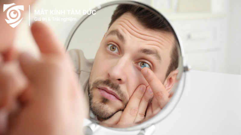 Người mới đang thực hiện cách đeo kính áp tròng trước gương