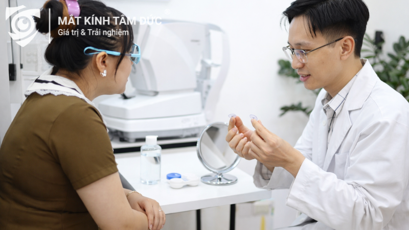 Chuyên viên tư vấn kính áp tròng cho khách hàng tại cửa hàng mắt kính