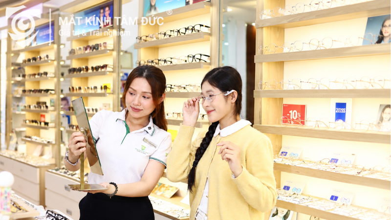Chuyên viên mắt kính tư vấn tròng kính mát có độ cho khách tại cửa hàng